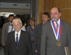 Pan Alfons Böhm v&nbsp;doprovodu starosty Ludgeřovic pana Mgr. Petra Kolarze, členů obecní rady a&nbsp;zástupců správy sociálního zabezpečení vchází do&nbsp;sálu Obecního domu.