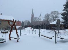 Sněhem zasypané dětské hřiště v&nbsp;Církevní mateřské škole Ludgeřovice.